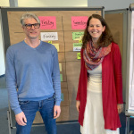 zwei Personen vor einer Pinnwand 